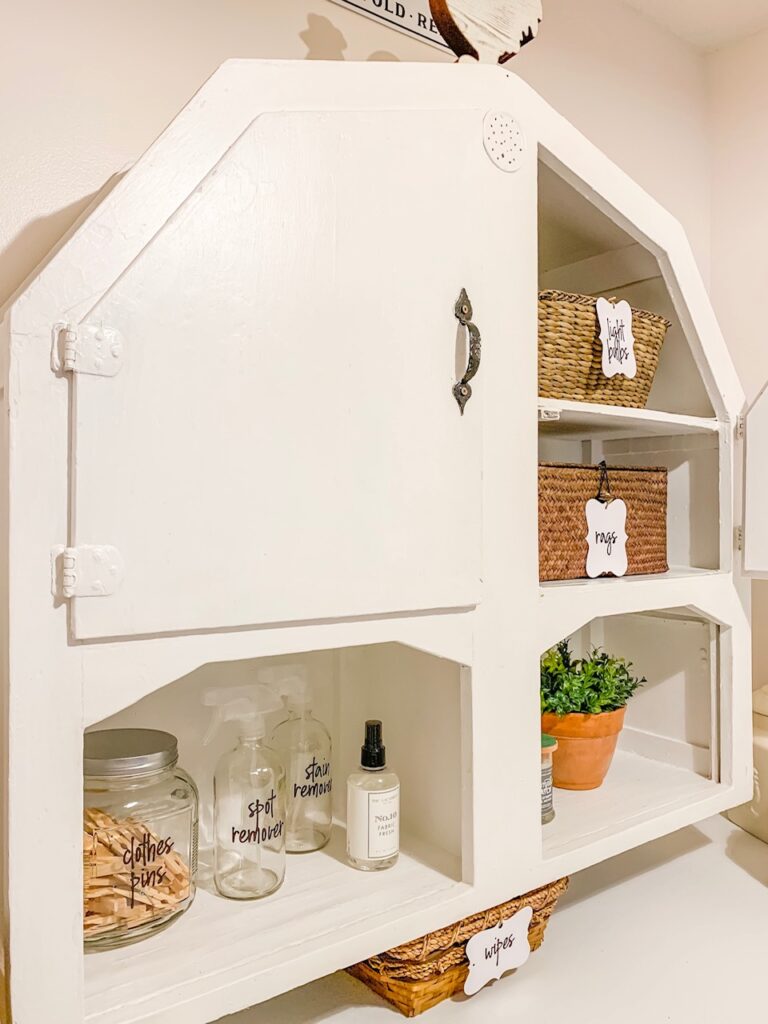 white painted primitive wood wall cabinet to hold supplies in laundry room makeover