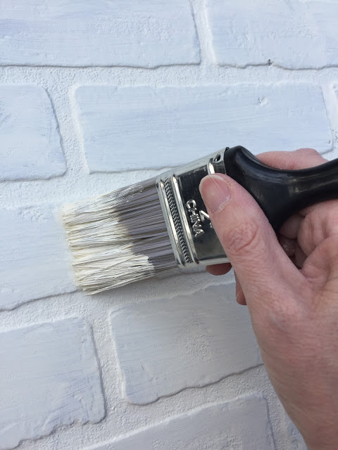 faux brick wallboard painted white for a kitchen backsplash