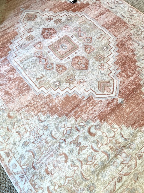 A beautiful blush area rug looks lovely in this cottage style home office