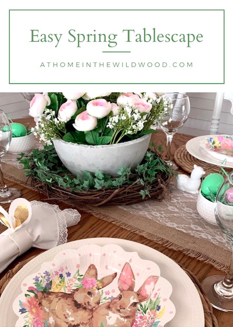 an Easter table centerpiece using an ivy wreath, concrete bowl, and pink faux flowers