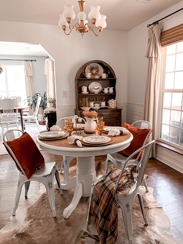 A cozy dining room space decorated for an early fall dinner