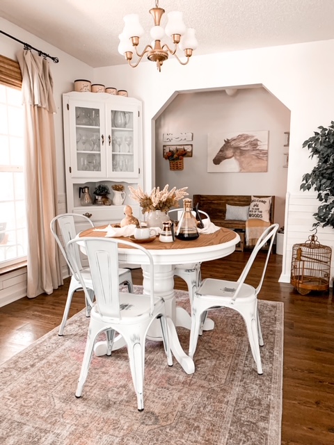 A cottage dining room decorated for fall with a neutral color scheme