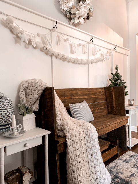 A front entry is decorated for winter with warm woods, and blue and white accessories