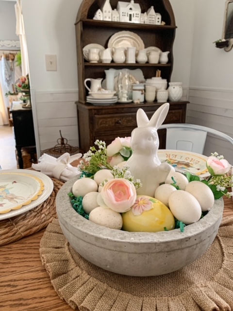 diy concrete bowl in center of table filled with eggs and a bunny for a Easter centerpiece