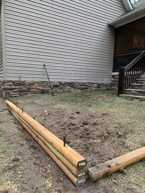 stacking the landscape timbers to create the sides of the patio