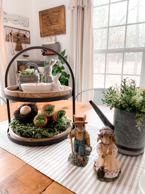 kitchen table styled with a tired tray, vintage bunny figurines, and a metal watering can